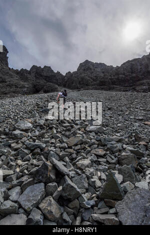 Männliche Hillwalker aufsteigend, der große Stein schießen, um den Gipfel der Sgurr Alasdair (Munro), der Black Cuillin, Skye, Schottland Stockfoto