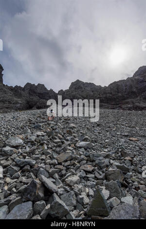 Männliche Hillwalker aufsteigend, der große Stein schießen, um den Gipfel der Sgurr Alasdair (Munro), der Black Cuillin, Skye, Schottland Stockfoto