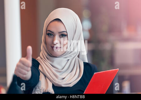 Arabian Business-Frau hält einen Ordner im modernen Startup-Büro Stockfoto