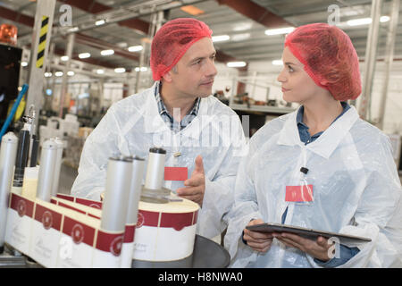 Arbeitnehmer in schützende Uniform, die Durchführung von Tests in der Produktionsstraße Stockfoto