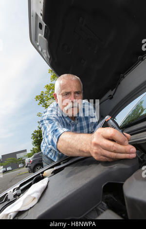 pensionierter Mann sein Automotor Service Stockfoto