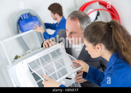 Klimaanlage-Techniker arbeiten an einer Einheit Stockfoto