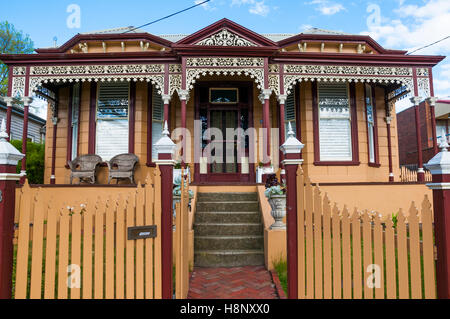 Späten viktorianischen Doppel-fronted Holz Haus in Melbourne, Anzeige der charakteristisch verzierten Veranda und Lattenzaun. Stockfoto