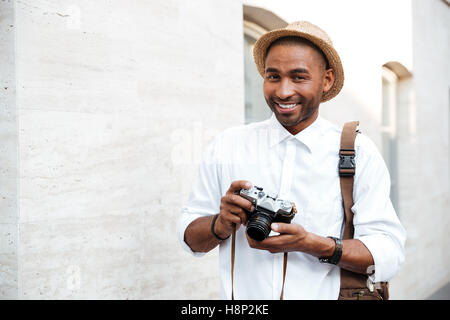 Porträt eines afrikanischen männlichen Fotografen. Lächeln auf den Lippen. auf der Straße Stockfoto
