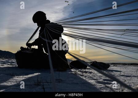 Ein US-Soldat packt seinen Fallschirm, nachdem ein Luftlandeausbildung Sprung von einer CH-47 Chinook Hubschrauber über der Malemute Drop-Zone auf der gemeinsamen Basis Elmendorf-Richardson 3. November 2016 in Anchorage, Alaska. Stockfoto