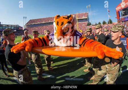 Clemson Universität Reserve Officer Training Corps Kadetten halten die Clemson Tigers Maskottchen so tun es Liegestütze Clemson erzielte einen Touchdown während der militärischen Wertschätzung-Spiel gegen Syrakus Universität in Clemson Memorial Stadium 5. November 2016 in Clemson, South Carolina zu feiern. Stockfoto