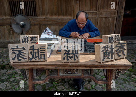 Ein Meister in der Kunst der chinesischen Movable Type Druck ausgebildet schnitzt aus Holz Zeichen Dongyuan Village, Ruian, China. Stockfoto