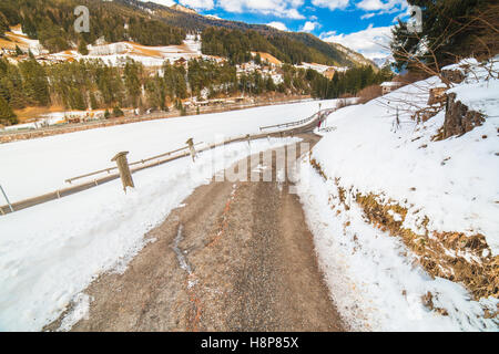 die Landstraße führt durch eine Winter-Berglandschaft. Stockfoto