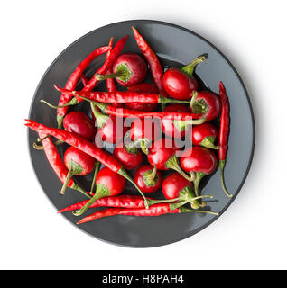 Rote Chilischoten auf Teller auf weißem Hintergrund. Stockfoto