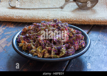 Salvia Officinalis zum Kochen von Tee auf einem schwarzen Untertasse und Teesieb für Teezubereitung auf den Matten Stockfoto
