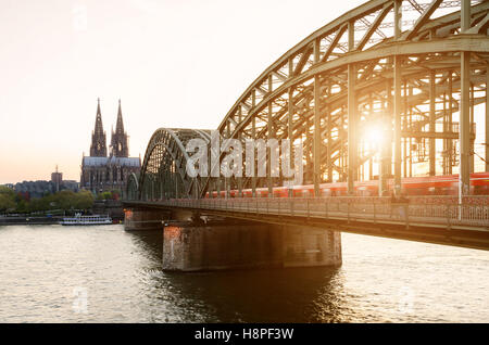 Köln, Deutschland. Bild von Köln mit Kölner Dom und Eisenbahn während des Sonnenuntergangs in Deutschland. Stockfoto
