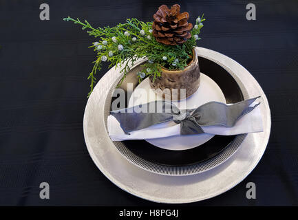 Evergreen in Tasse mit Christmas Platte Einstellung auf schwarze Tischdecke Stockfoto