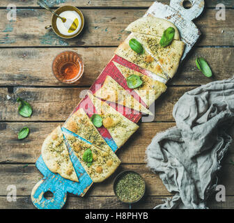 Focaccia mit Basilikum Blätter, Olivenöl, Wein auf bunten board Stockfoto