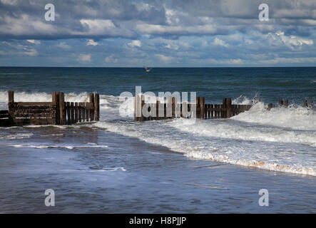 Wellen brechen über die Stützmauer Küstenschutzes an der North Norfolk-Küste Stockfoto