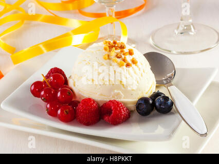 Hausgemachtes Vanille-Eis mit Nüssen, Heidelbeeren, Himbeeren und rote Beeren Stockfoto