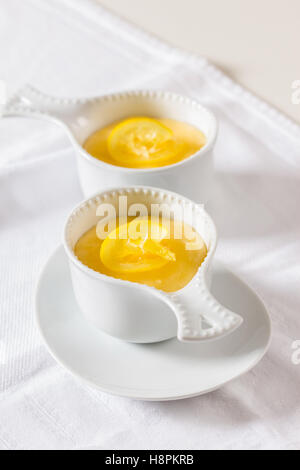 Zwei Schüsseln mit Pudding Dessert Zitrone auf einem weißen Tisch Stockfoto