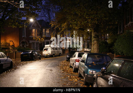 Herbst Blätter bedecken die Bürgersteige und Straßen in einer typischen Süd-London-Straße nach Einbruch der Dunkelheit auf eine nasse Nacht Stockfoto