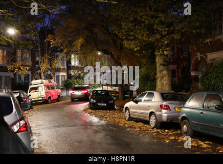 Herbst Blätter bedecken die Bürgersteige und Straßen in einer typischen Süd-London-Straße nach Einbruch der Dunkelheit auf eine nasse Nacht Stockfoto