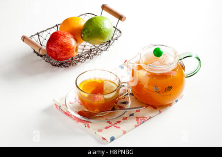 Kanne orange Tee und Tasse mit Obst auf weißem Hintergrund Stockfoto