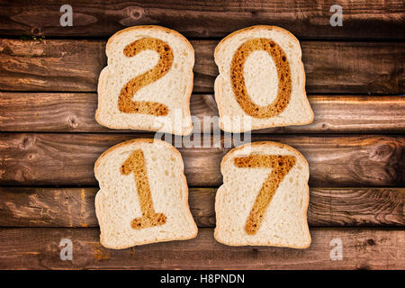 2017-Grußkarte geröstete Brotscheiben auf Holzbohlen Hintergrund Stockfoto