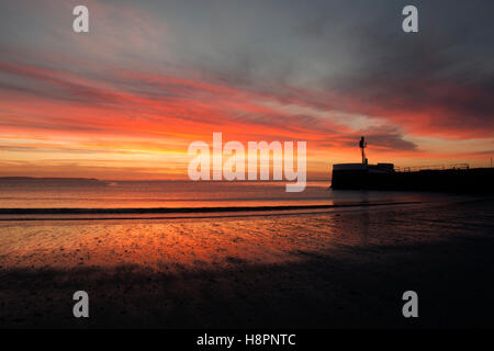 Sunrise-Reflexionen über East Looe Beach und Banjo Pier als die Flut erlischt am Remembrance Day Sonntag 2016 Stockfoto