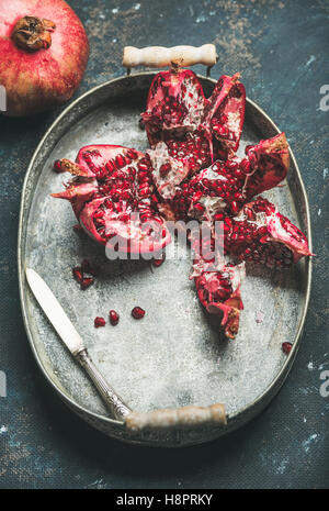 Frische reife Granatapfel in Metalltablett auf dunkelblauem Hintergrund Stockfoto