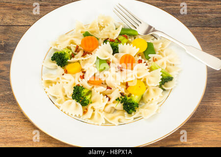 Farfalle mit Brokkoli, Karotten, Bohnen und Wurst Stockfoto