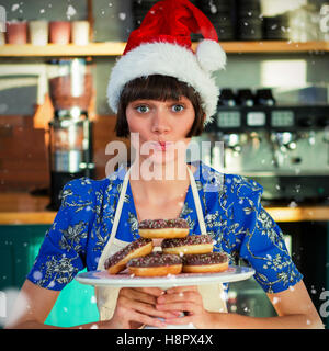 Zusammengesetztes Bild Porträt der Kellnerin hält Tablett mit Krapfen Stockfoto