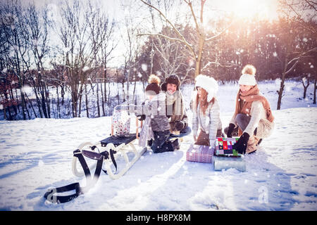 Zusammengesetztes Bild der Familie mit Schlitten auf schneebedeckten Feld spielen Stockfoto