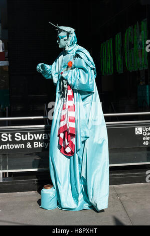 Straßenkünstler gekleidet wie die Statue of Liberty, arbeiten auf dem Bürgersteig, die versuchen, Touristen zu fotografieren gegen Gebühr zu locken. Stockfoto