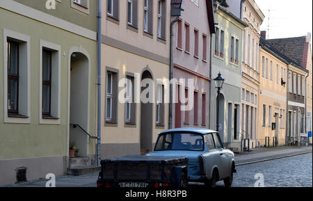 Luckau, Deutschland. 14. November 2016. Ein Trabant Auto fährt durch das renovierte alte Stadt von Luckau, Deutschland, 14. November 2016. Arbeitenden Gruppe "Städte mit einer Historicak Innenstadt" des Landes Brandenburg hat das Gebäude der ehemaligen Schreinerei und Möbel Firma Wilhelm Paternoster Denkmal des Monats ernannt. Foto: Bernd Settnik/Dpa/Alamy Live News Stockfoto