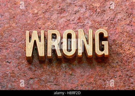 falsches Wort aus metallischen Lettern auf rotem rostige Oberfläche hergestellt Stockfoto