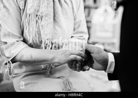 Sohn Mutter Hand in Segen halten. In der Kirche zu pflegen Stockfoto