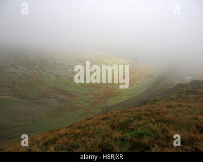 auf der Suche nach unten Riggindale, eingehüllt in eine Wolke aus Riggindale Crag auf High Street über Haweswater in Mardale Seenplatte Cumbria Stockfoto