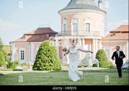 Laufenden und glückliches Hochzeitspaar Hintergrund altes Herrenhaus Stockfoto