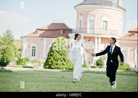 Laufenden und glückliches Hochzeitspaar Hintergrund altes Herrenhaus Stockfoto