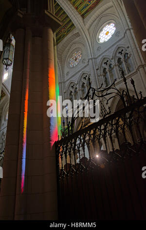 Farben des Regenbogens projiziert auf einer Spalte von Glasfenster in der Kathedrale "Almudena" Madrid Stockfoto