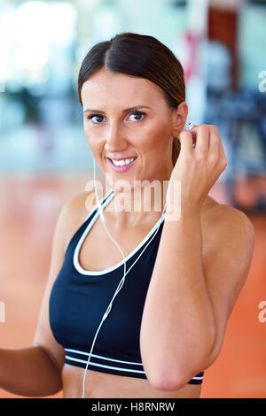 Frau Musik auf Smartphone setzen Kopfhörer vor dem Training einstellen Stockfoto