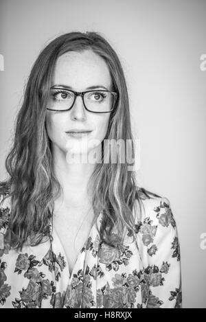 Schöne rote Schülersprecherin schwarz-weiß in schwarze Brillen Stockfoto