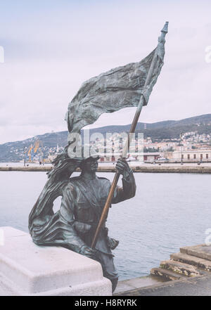 Bronze von Bersagliere Soldat Statue mit Fahne in Triest. Skulptur, die Lote an der Uferpromenade in Triest, Italien. Stockfoto