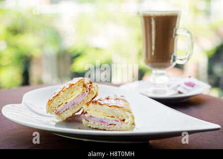 geröstetem Schinken und Käse Croissant mit Latte Kaffee Frühstück Set snack Stockfoto