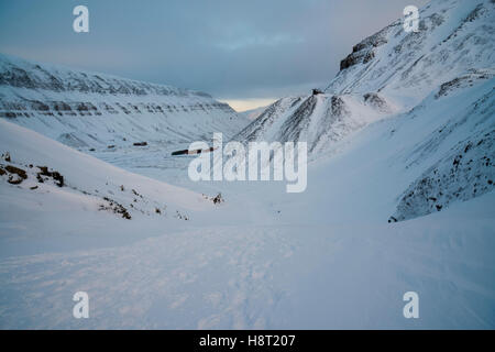 Auf dem Weg nach Larsbreen im Winter Svalbard blicken Sie zurück durch die Berge nach Longyearbyen und zum Berg Platåberget. Longyearbyen, Spitsbergen, Norwegen Stockfoto