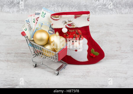 Warenkorb mit Euro-Banknoten und Weihnachtsdekoration Stockfoto