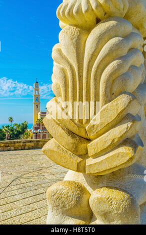 Der Glockenturm der St. Peter Kirche sieht man hinter der Steinskulptur in Abraham Shechterman Garten von Jaffa, Tel Aviv Stockfoto