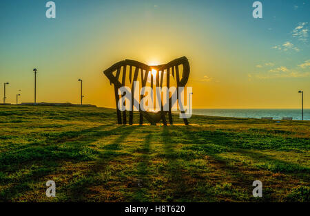 Den malerischen Sonnenuntergang im Stadtpark, wird die Sonne durch das steinerne Herz an Küste, Tel Aviv, Israel gesehen. Stockfoto