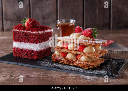 Mille Feuille Dessert süße Stück roten Samt-Kuchen mit weißem Zuckerguss ist mit Erdbeeren garniert Stockfoto