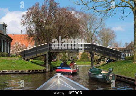 GIETHOORN, Niederlande - 3. April 2016: Unbekannte Menschen in Booten genießen ihre Sightseeing-Bootsfahrt in einem Kanal in Giethoorn, al Stockfoto