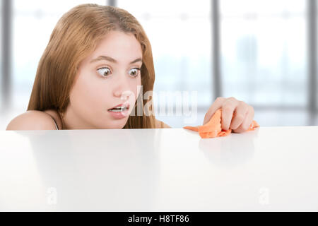 Frau in Panik versucht, Keime aus ihrem Schreibtisch reinigen Stockfoto