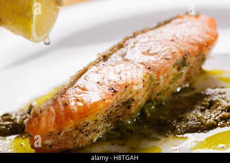 Frische Lachs Steak mit Pesto Sauce, Top Tropfen Zitrone Stockfoto