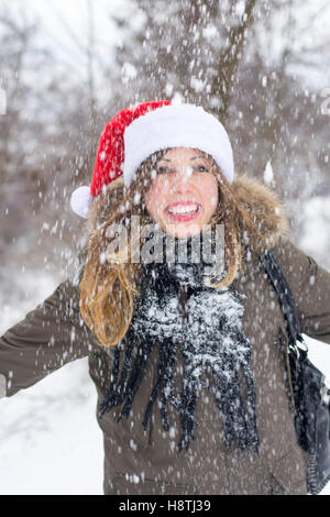 Frau genießt Wintertag im Schnee bedeckt park Stockfoto